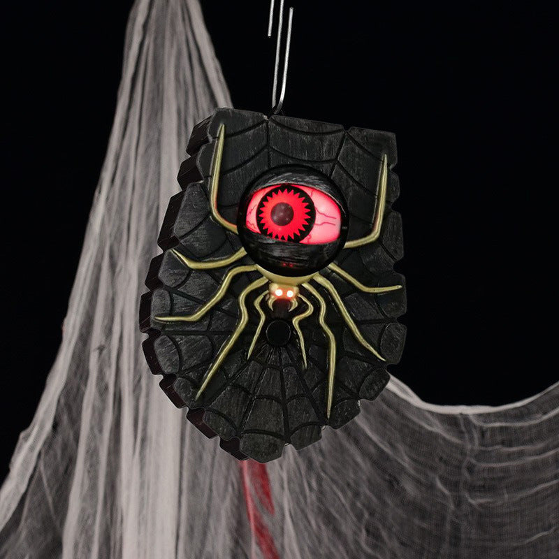 Black spiderweb spider Halloween doorbell with a glowing red eyeball hanging from a loop on cobwebs