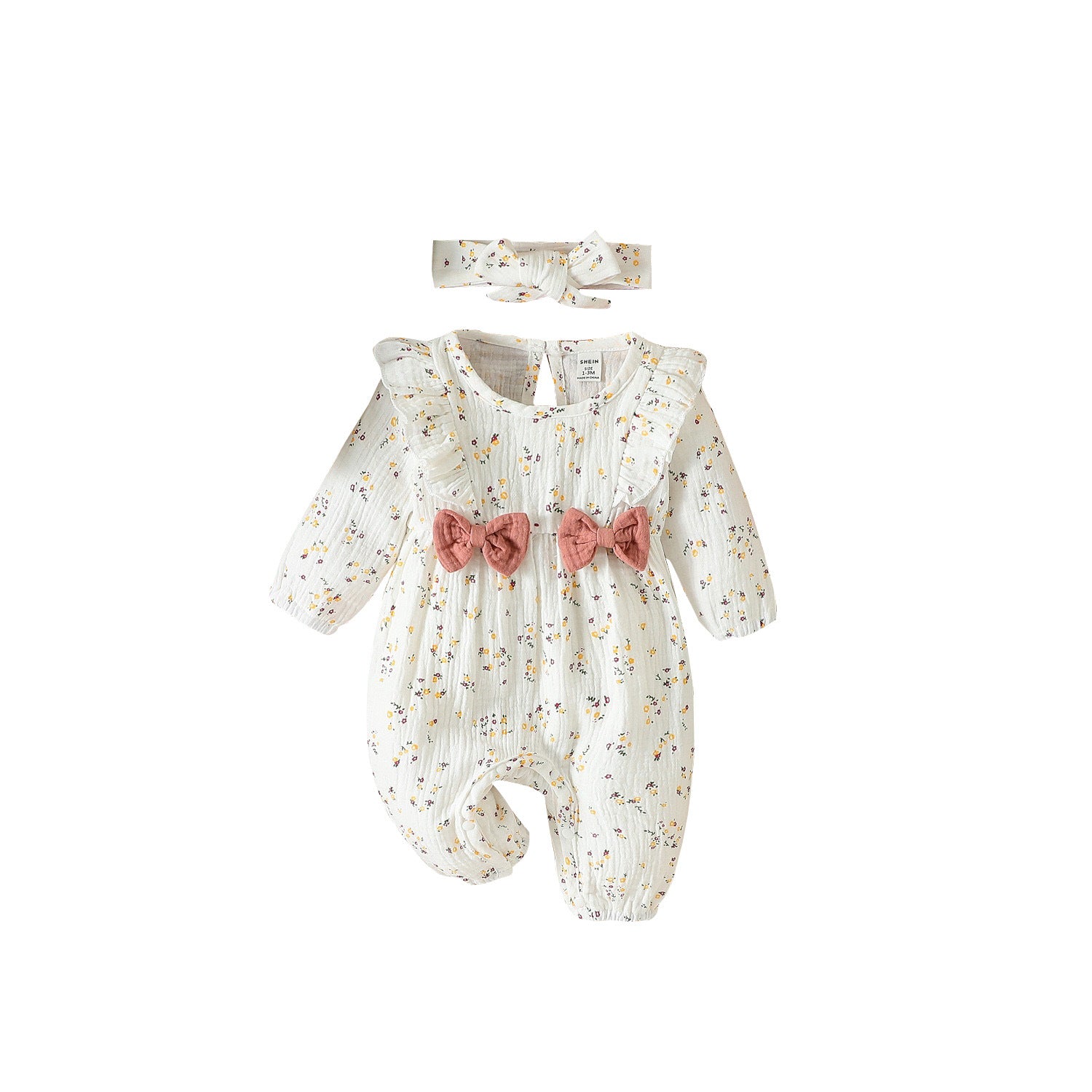 Baby floral romper held in hand to show its small newborn scale