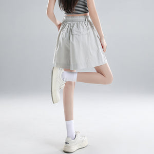 Back view of gray washed cotton wide-leg shorts showing welt pocket and elastic waist