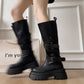 Model wearing black platform buckle boots, tall mid calf shaft over bare legs