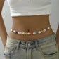 Cowrie shell waist chain alternating with dyed star beads in blue, yellow, purple and red