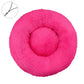 Rose red round plush pet bed with a raised bolster rim on a plain background