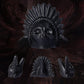 Matte black ceramic skull death whistle with carved feather headdress shown with front and side views