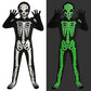 Black skeleton jumpsuit with white bone print, skull hood and gloves beside the same costume glowing green