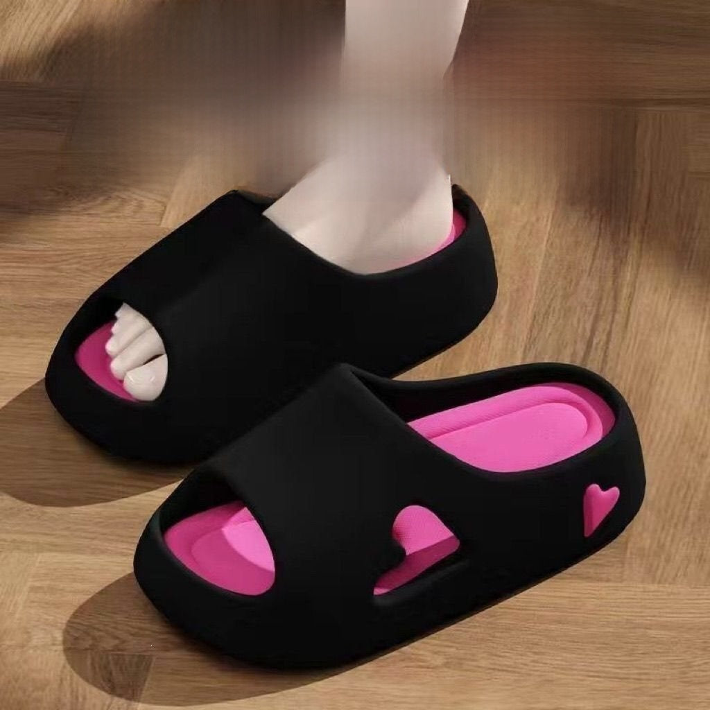 Black EVA platform slide sandal worn on a foot over a wood floor