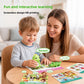 Mother and young boy at a table placing a green dinosaur reader on a picture card, a screenless design