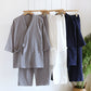 Gray, white and navy kimono style cotton gauze pajama sets hanging on wooden hangers beside a green plant