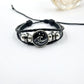 Black braided cord bracelet with a mountain charm and three strand weave