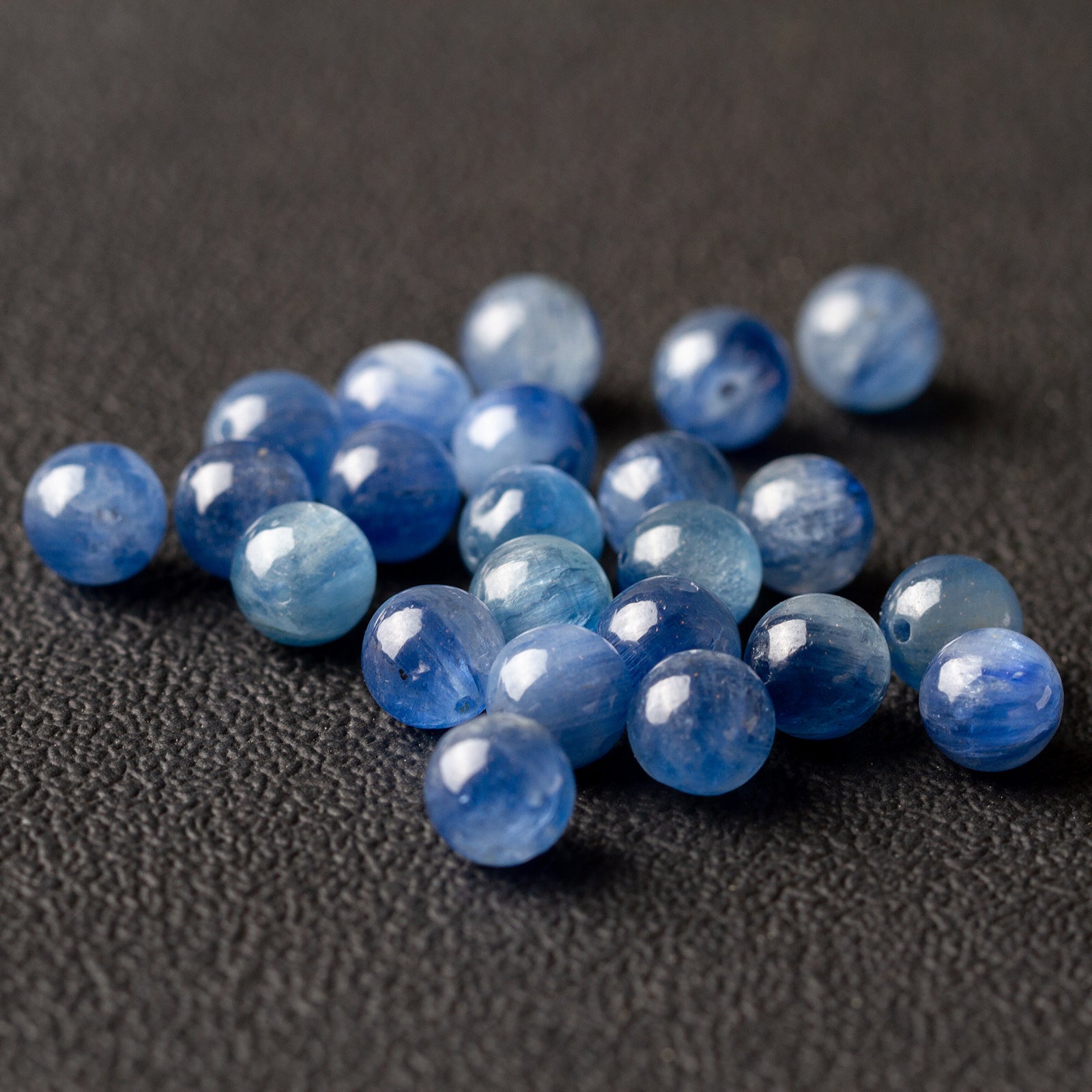 Close-up of blue kyanite gemstone beads showing the natural paler banding
