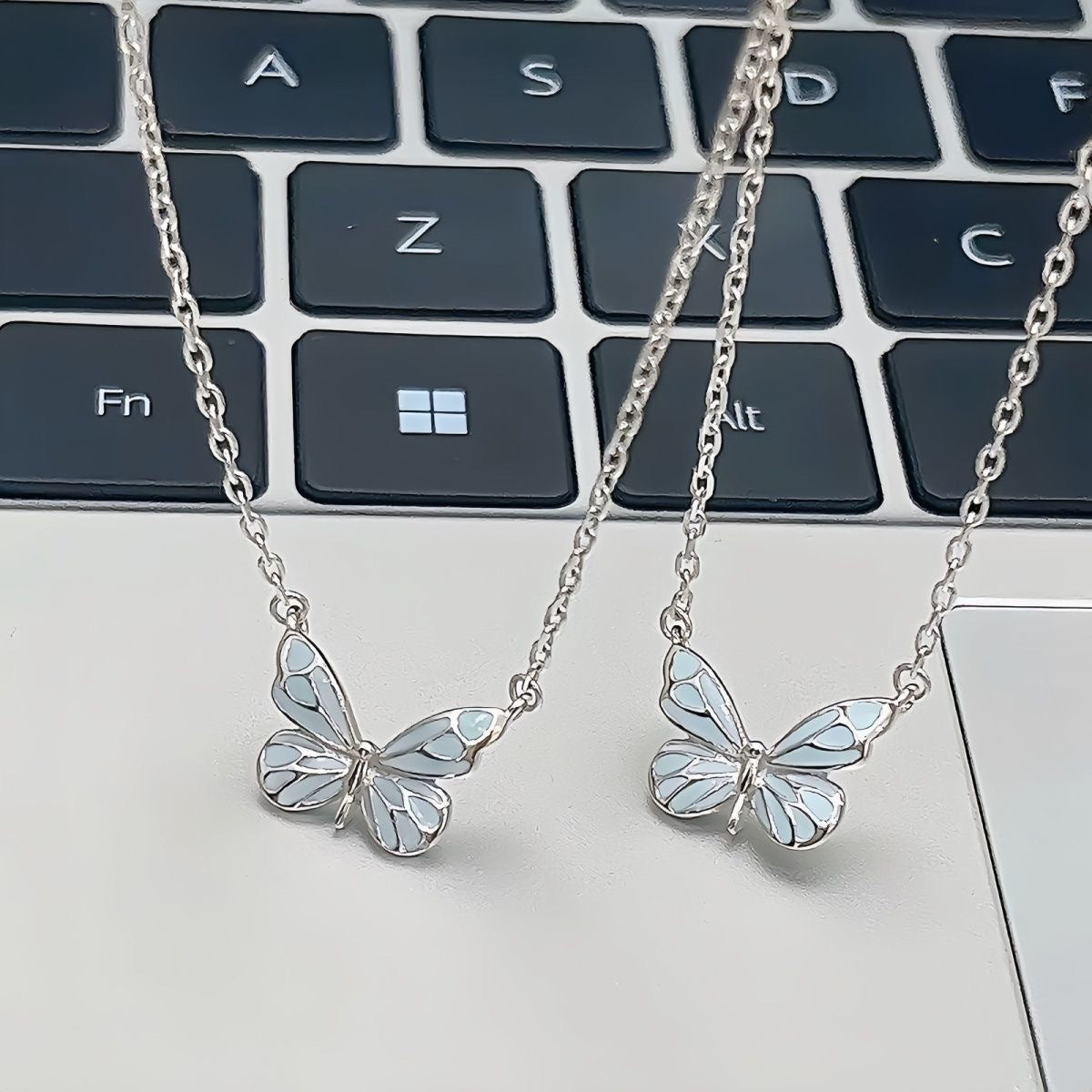 Blue butterfly pendant necklace worn at the neckline in daylight