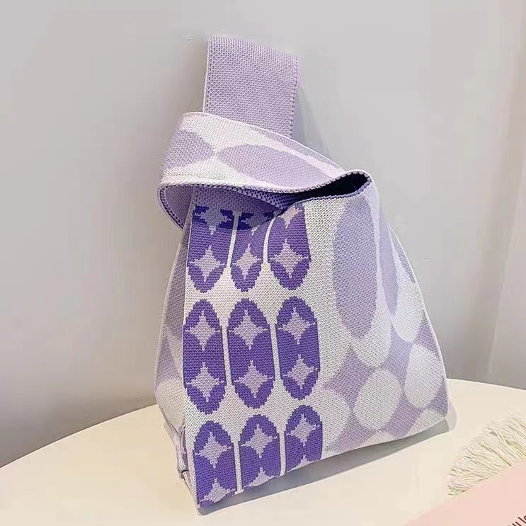 Jacquard knit wrist bag shown from the front with its loop handle upright