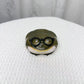 Olive resin frog earbud case wearing round black spectacles, closed, on a white cloth