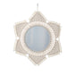 Boho wall mirror hung above a console reflecting daylight in the room