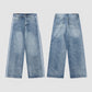 Wide-leg washed denim jeans worn with chunky trainers in a room setting