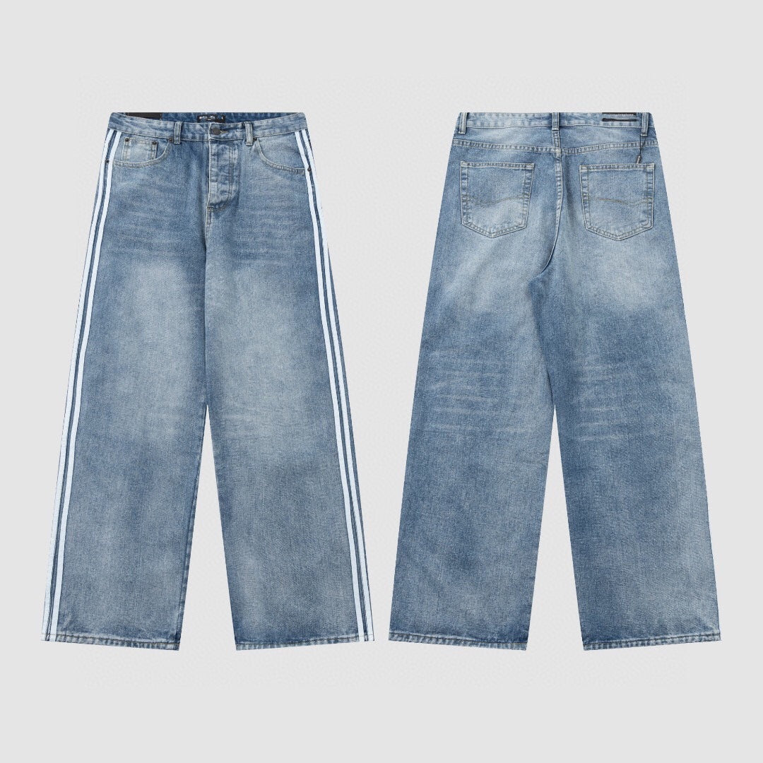 Wide-leg washed denim jeans worn with chunky trainers in a room setting