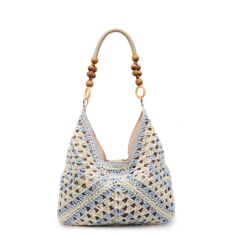 Khaki and cream open-weave hobo bag with a dark wooden bead handle on a plain white studio background