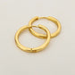 Gold hoops placed inside their dust pouch on a bathroom shelf