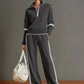 Grey half zip sweatshirt and wide leg pants set with white piping, worn full length