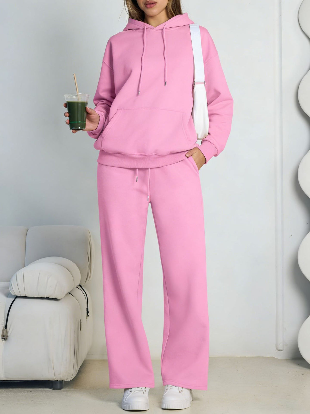 Pink fleece hooded sweatshirt and wide-leg sweatpants set worn by a model