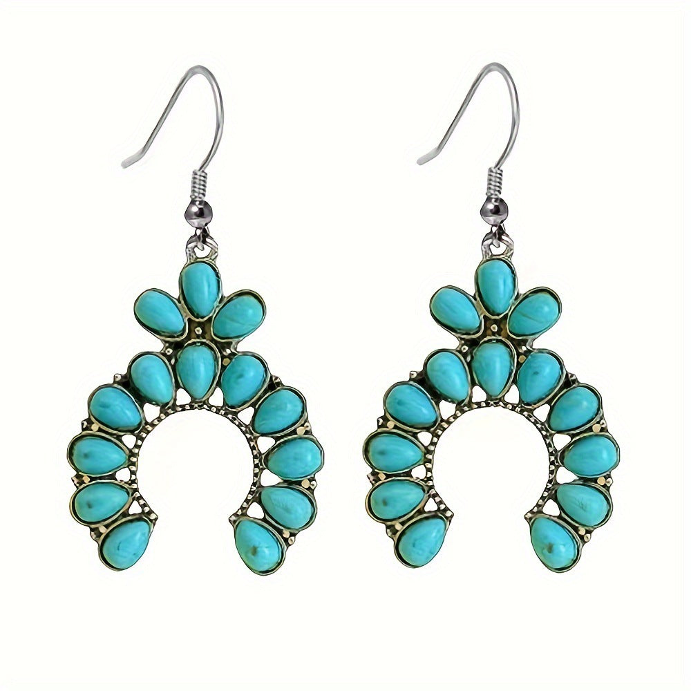 Pair of antique silver tone crescent drop earrings with turquoise colored stones hanging from fish hook ear wires