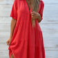 Red short sleeve cotton and linen tiered shirt dress worn by a model with a lapel collar and two button placket