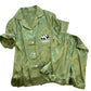 Moss green short sleeve ice silk pajama set with white piping, shirt and shorts laid flat