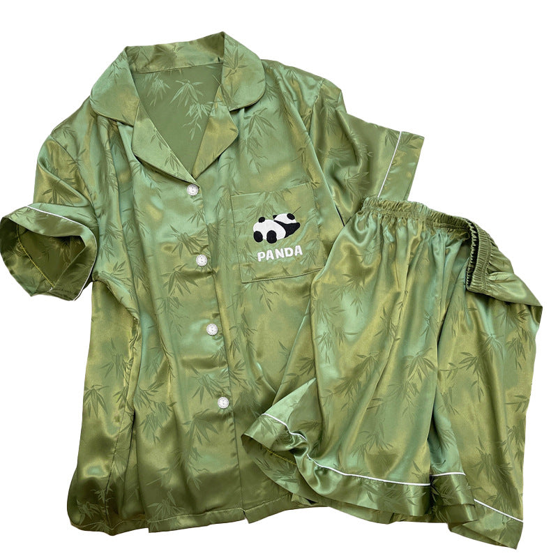 Moss green short sleeve ice silk pajama set with white piping, shirt and shorts laid flat