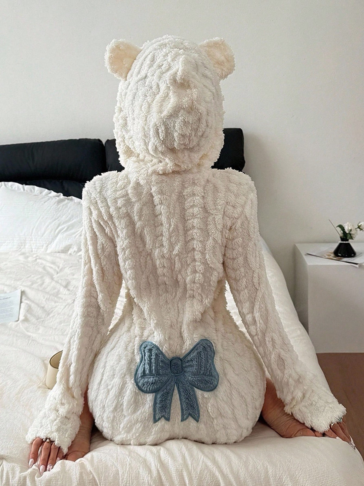 White plush hooded romper with bear ears seen from behind, seated, size M option photo