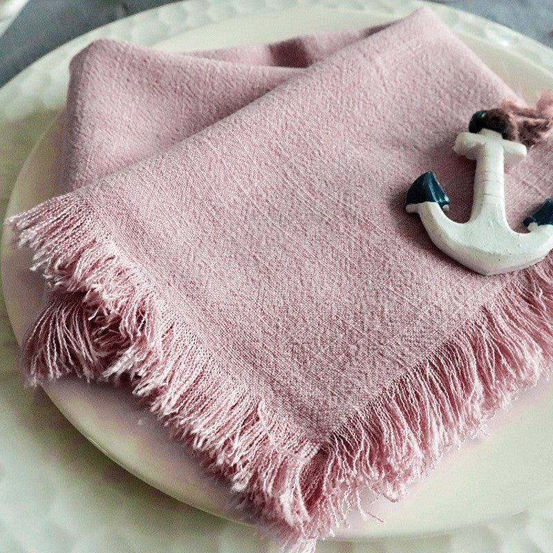 Close up of the cotton-linen weave and short tassel trim on a napkin