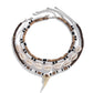 Four strand necklace set flat on white, lobster clasps and extender chains visible at the top