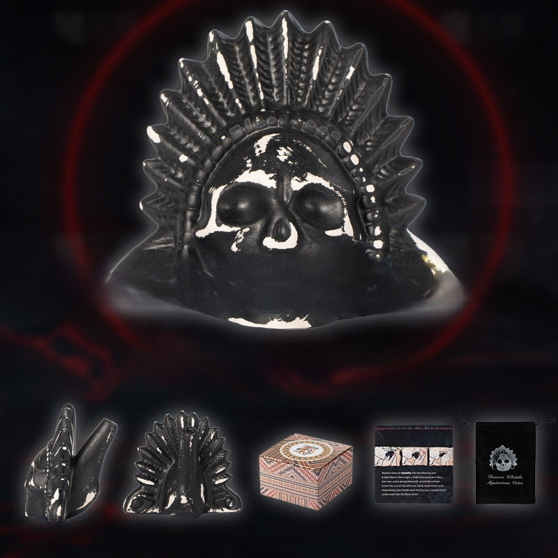 Black and white ceramic skull death whistle with feather headdress shown with side views, box and storage bag