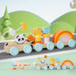 Pastel wooden pull along train with animal figures and rainbow stacker on a toy road scene