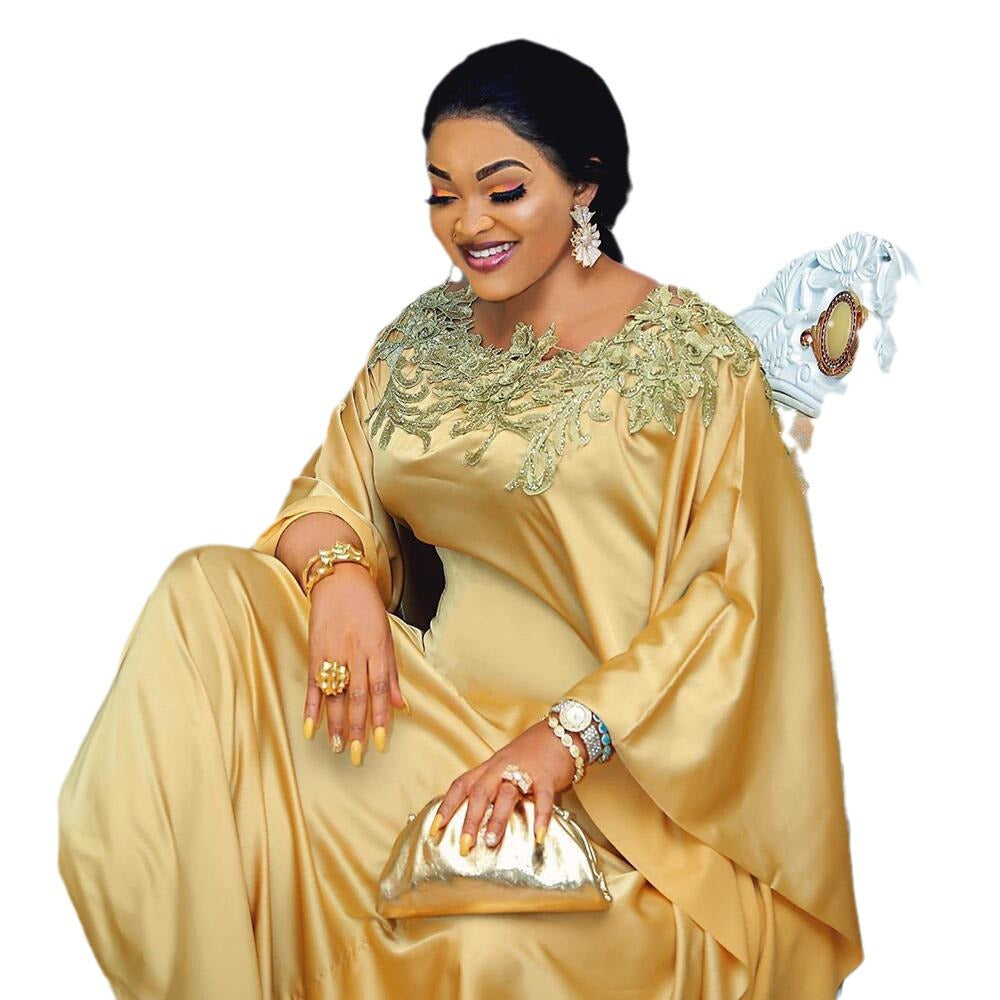 Gold satin maxi dress showing the lace yoke and flowing sleeves on a model
