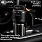 Black stainless steel travel mug seated in a car center console cup holder on its narrowed base