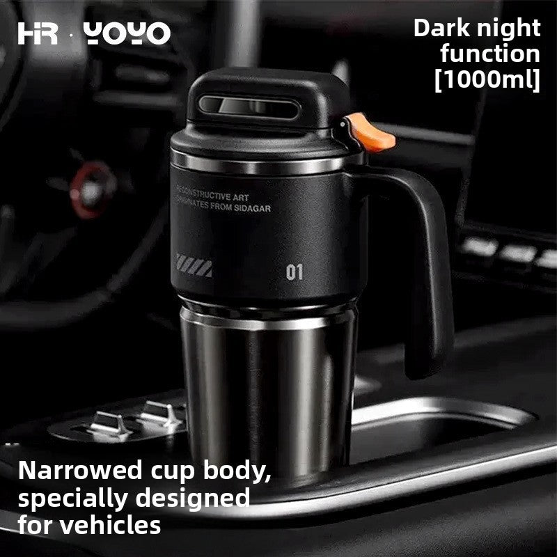 Black stainless steel travel mug seated in a car center console cup holder on its narrowed base