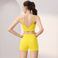 Back view of a woman in a vivid yellow V-back sports bra and high-waist shorts set, size L option
