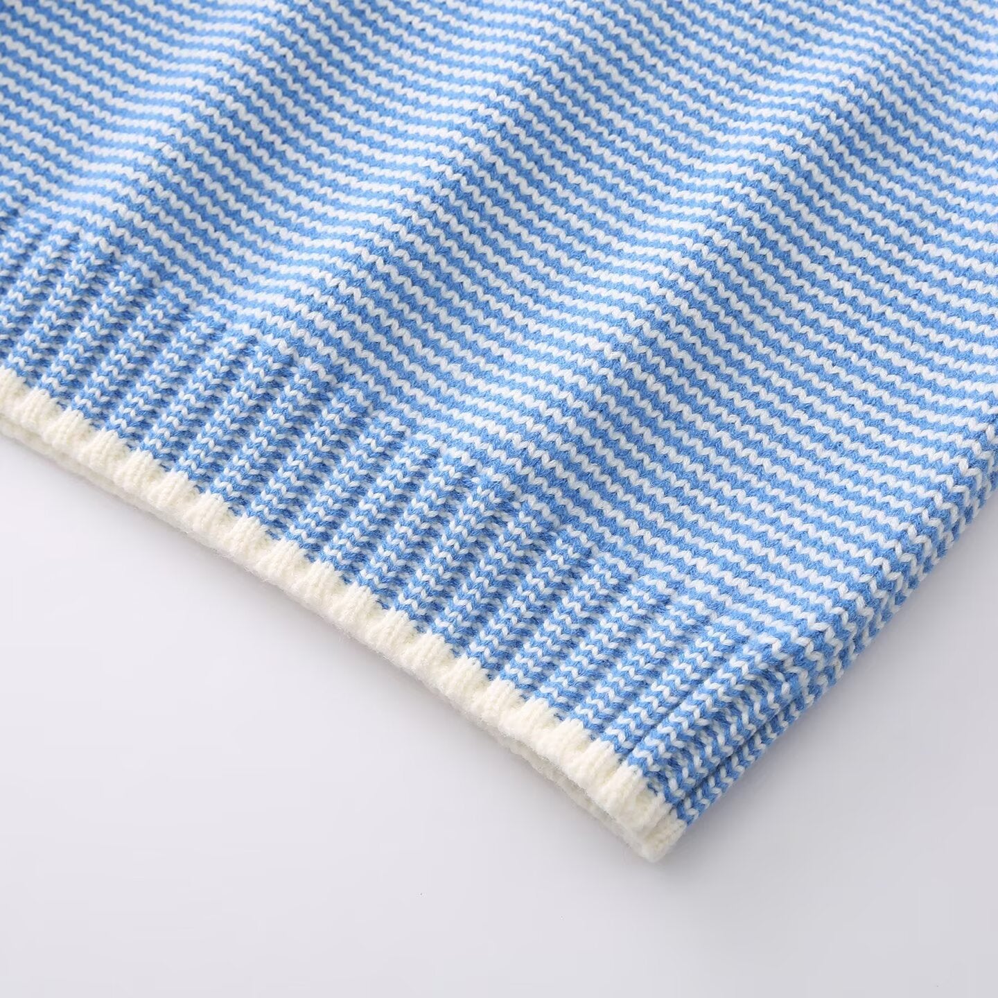 Close up of the knit blend yarn and horizontal stripe texture on the blue sweater