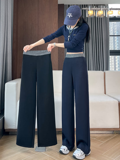 Navy fleece-lined wide-leg pants held up beside a woman wearing them, showing the gray elastic waistband