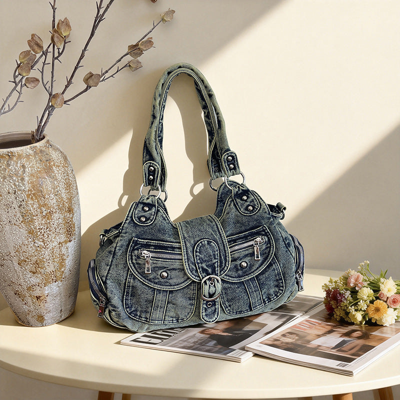 Blue washed denim shoulder bag styled on a table beside a vase and flowers