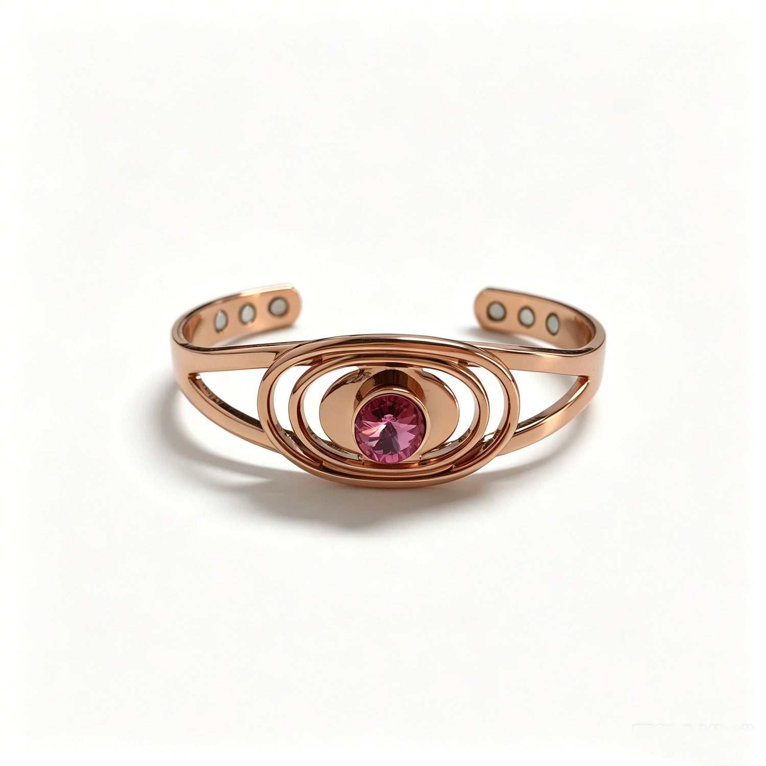 Copper cuff bracelet with faceted pink cubic zirconia and six magnets, white studio background