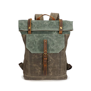 Front view of olive green and teal green canvas roll-top backpack with brown buckle strap and top handle