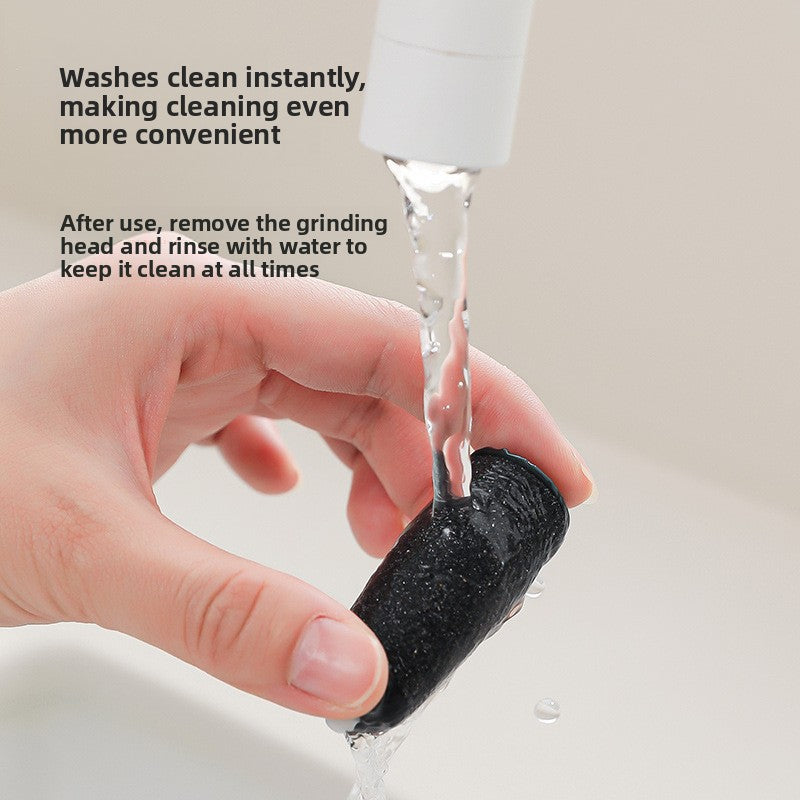 Detached grinding head being rinsed clean under running tap water by hand