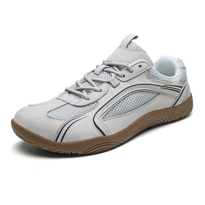Light gray low-profile lace-up mesh sneaker with a gum brown flat rubber sole and dark piping lines, angled side view