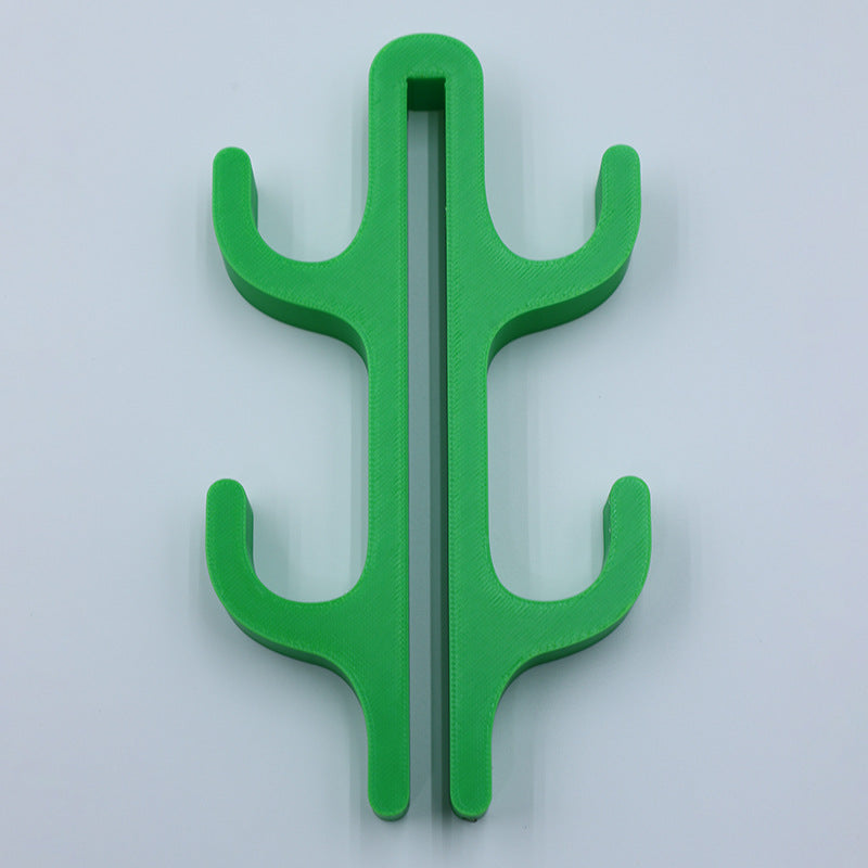 Green resin four hook with four arms, seen from the front on a light background