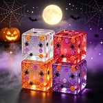 Four Halloween glitter squishy cubes in red purple orange and clear on a moonlit scene