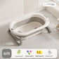 Empty cream and gray foldable baby bathtub with folding stand and gift pack of bath toys below