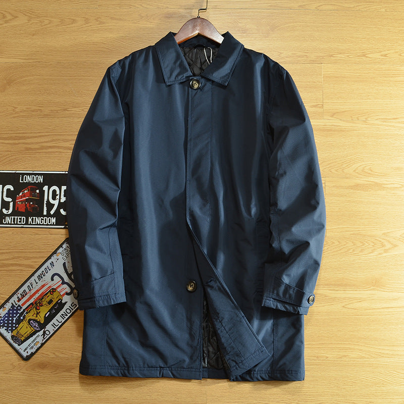 Navy blue mid-length quilted lined coat with lapel collar and covered button front on a hanger, size XS option