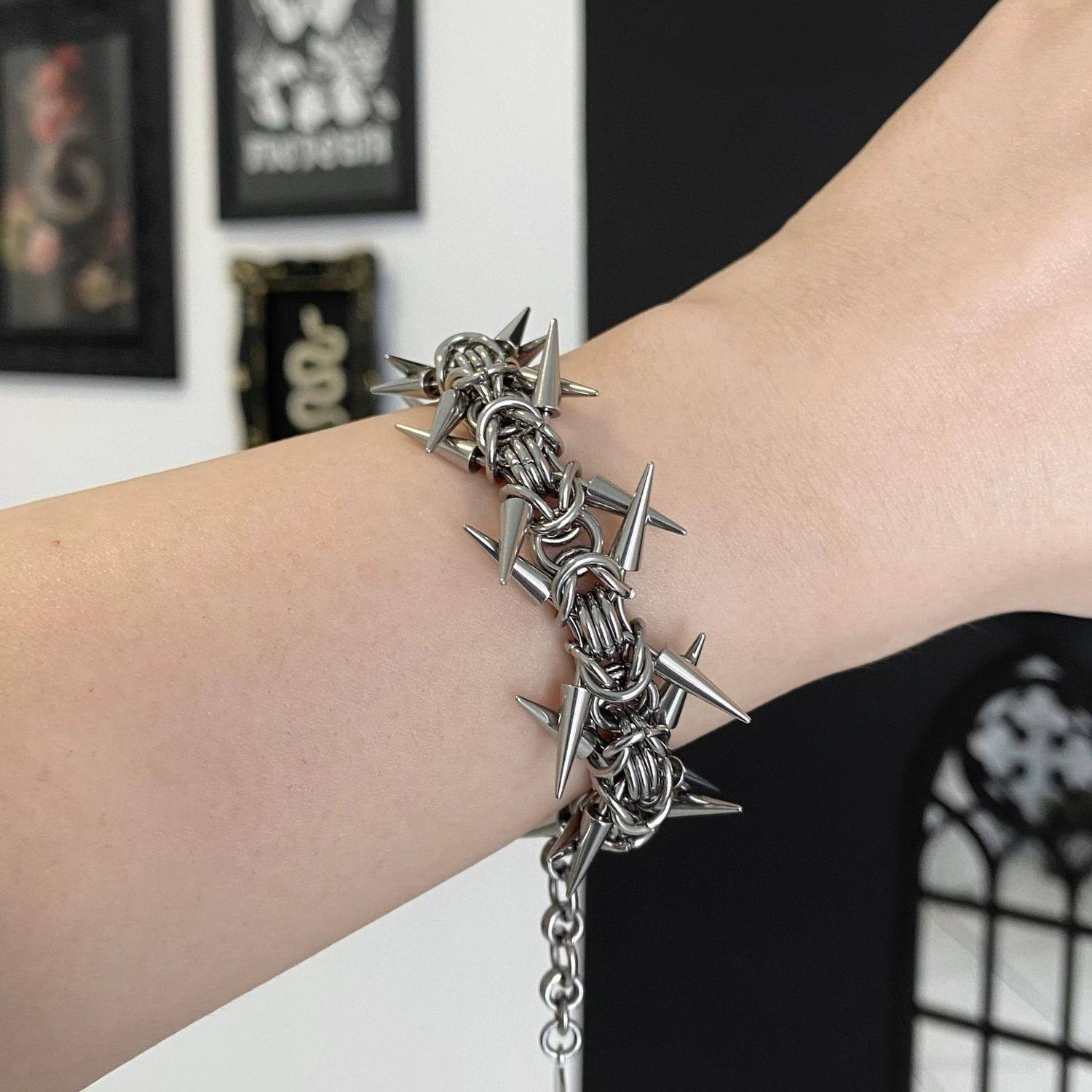 Woven metal chainmail band set with polished cone spikes all the way round