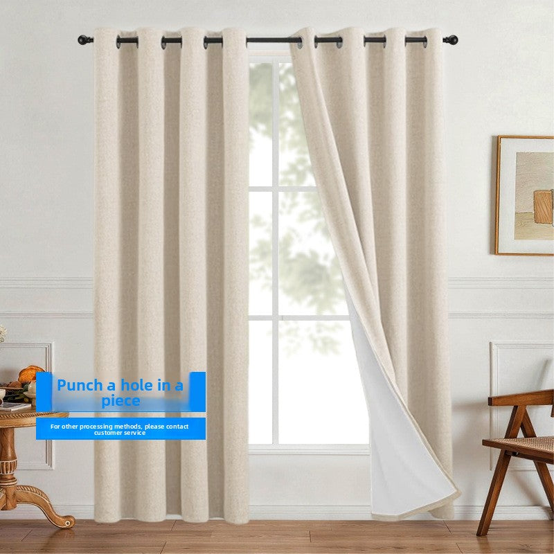 Linen look polyester blackout grommet curtain panel with white thermal backing pleated on a slim black rod over a tall window