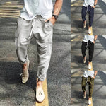 Light gray ribbed corduroy cargo pants with drawstring waist worn on a street, with navy, black and olive versions beside